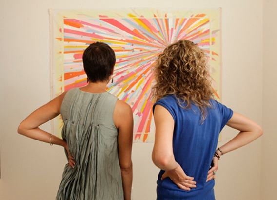 two women looking at a painting